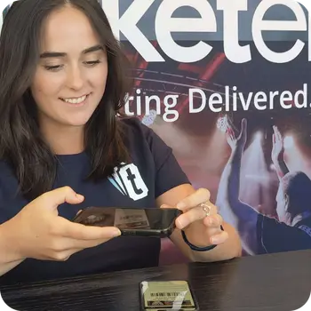 Ticketebo staff member scanning a ticket with a handheld device at an event entry desk.